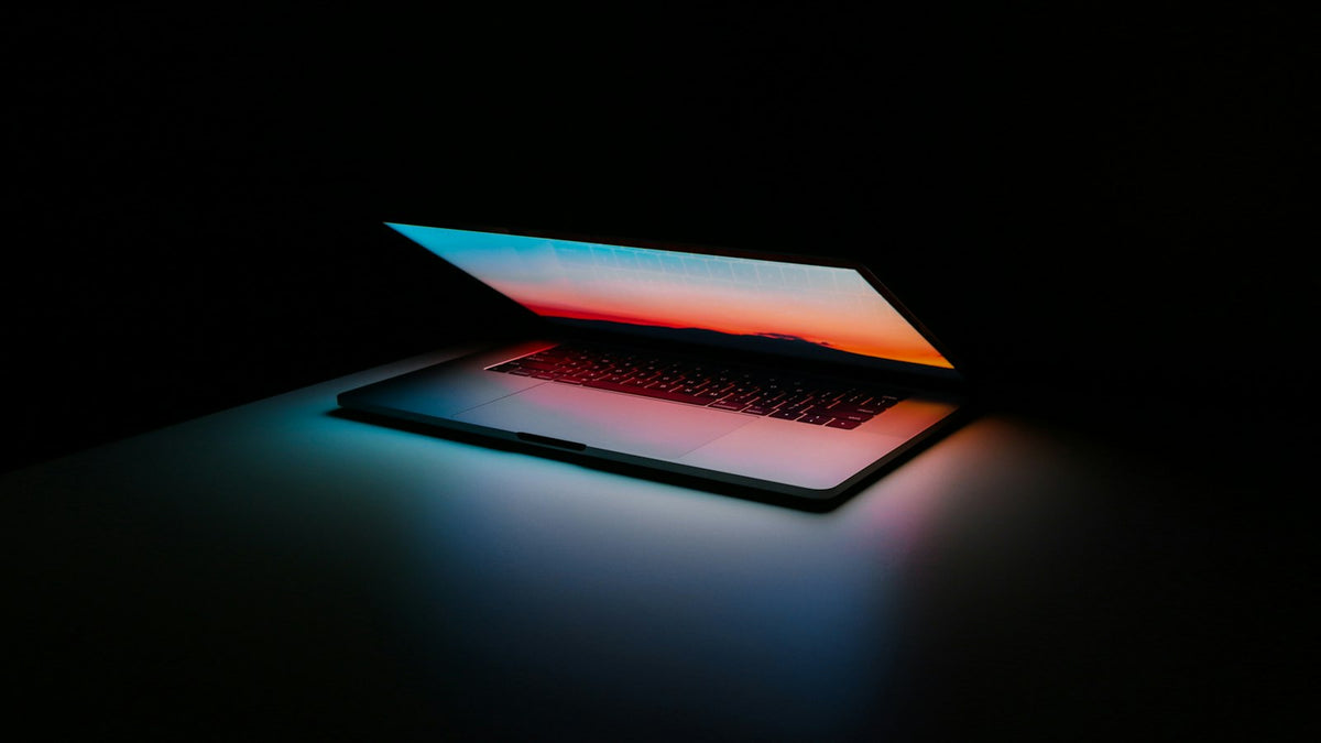 Laptop on a desk showing a website homepage design
