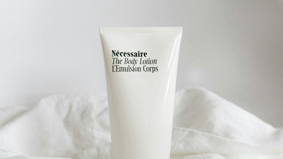 Body lotion tube photographed on soft white fabric