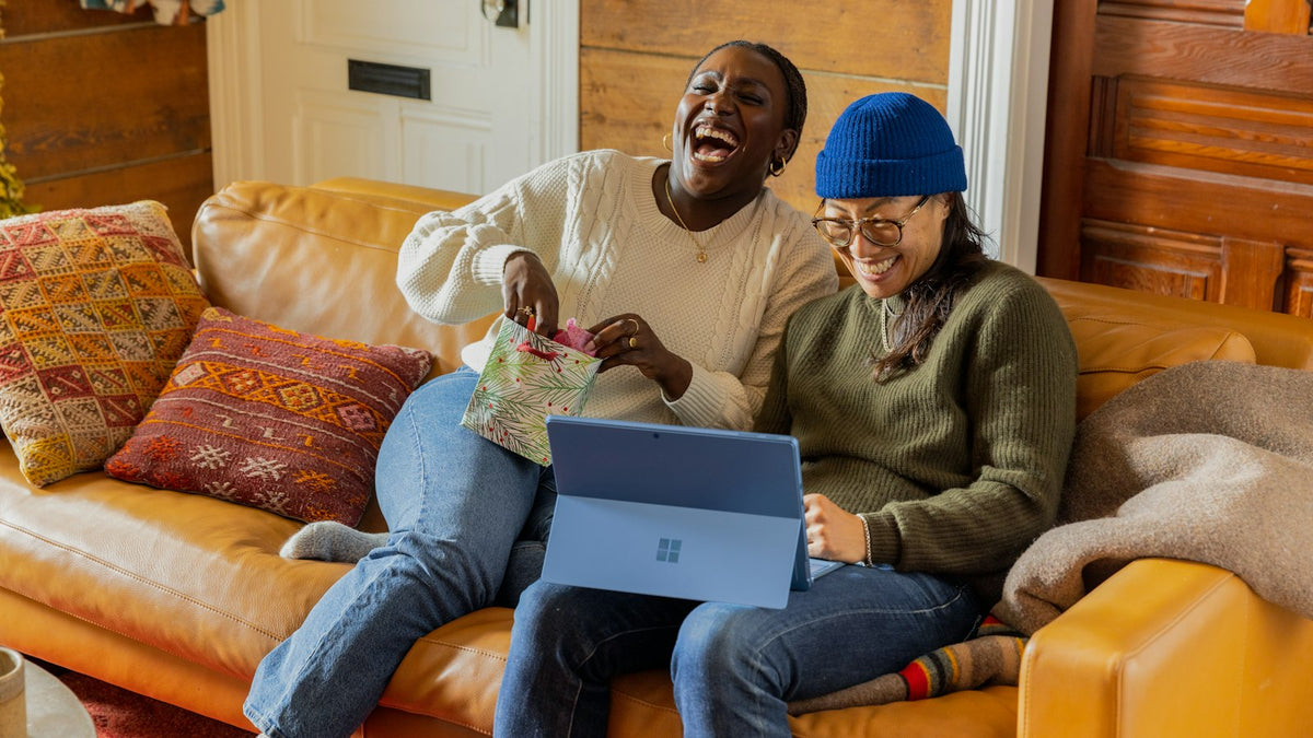 Person shopping online on a laptop from a couch