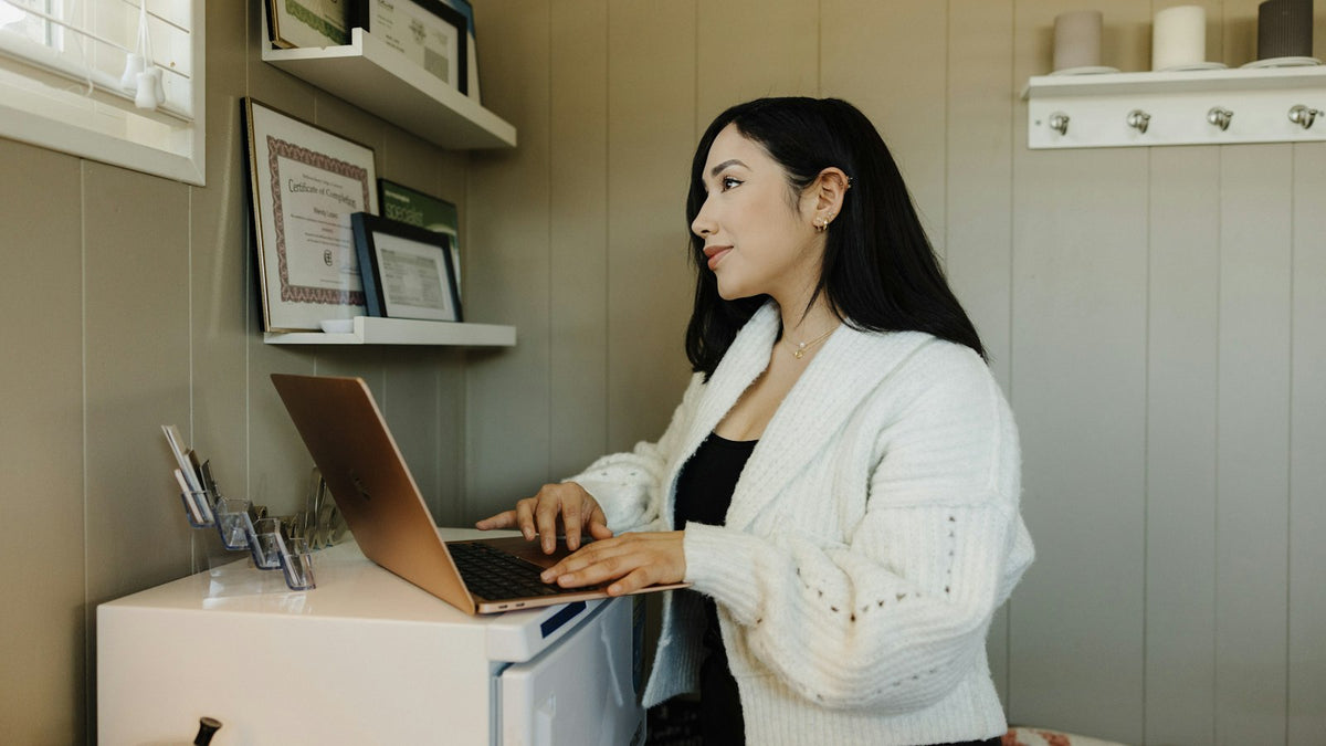 Woman at a desk using a laptop to manage clinic appointments