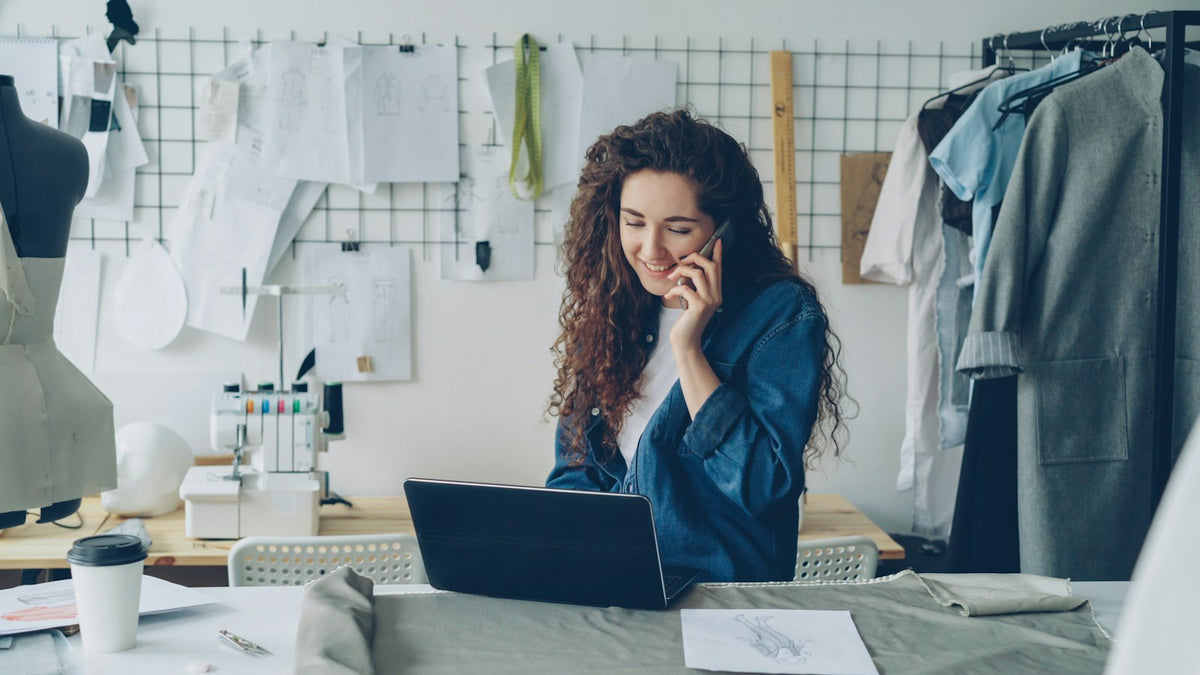 Fashion designer working on a laptop while on the phone