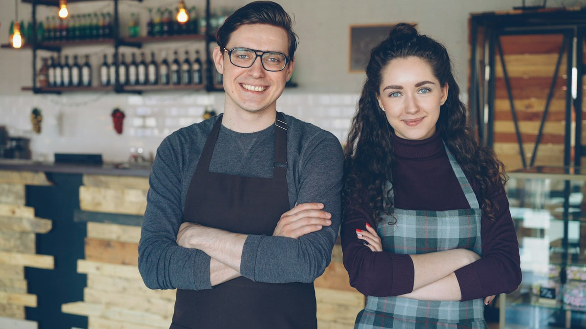 Two cafe owners standing proudly in their cafe